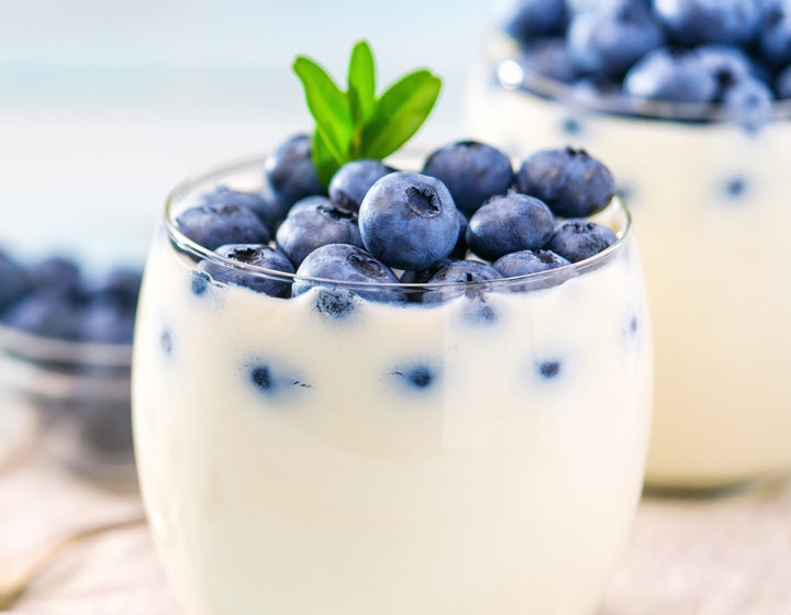Glass of yogurt topped with fresh blueberries, illustrating clean label cultured dairy