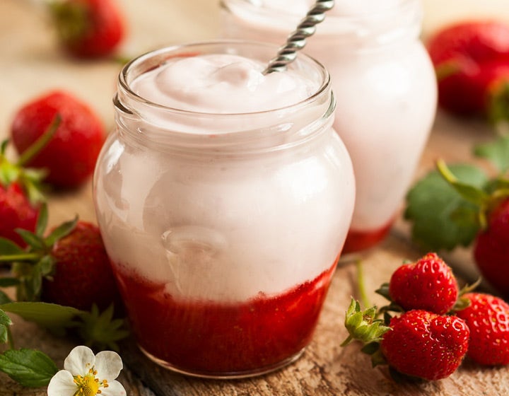 Jar of strawberry yogurt with spoon, highlighting fruit prep innovation