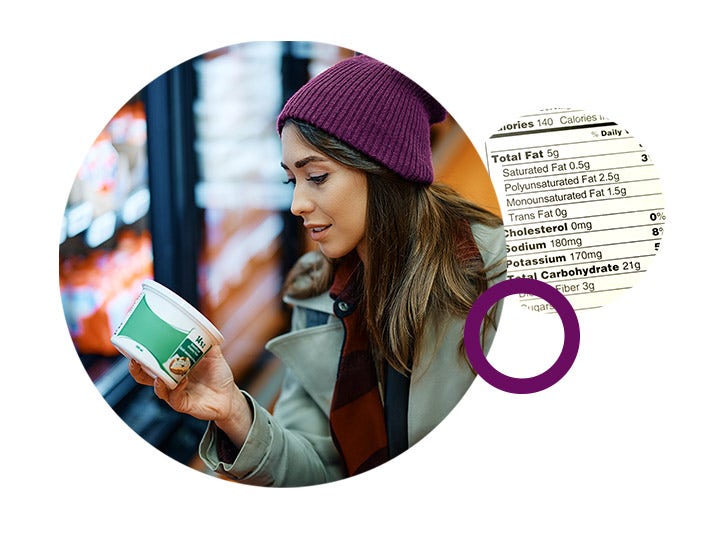 Woman reading a nutrition label on packaged food, emphasizing healthier dairy choices